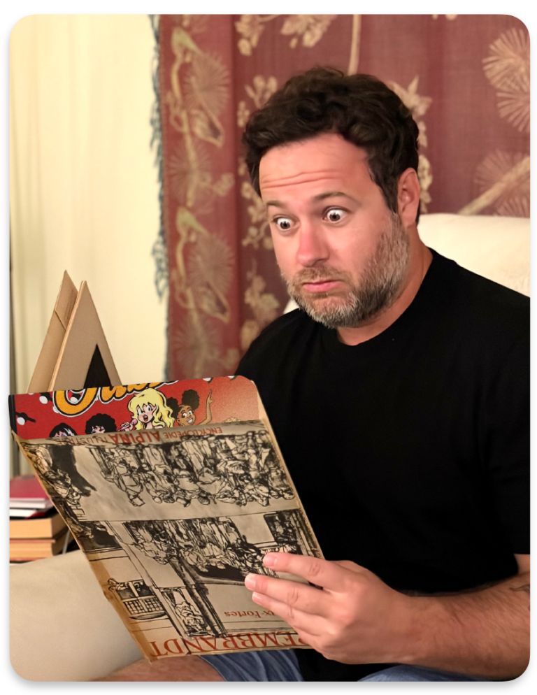 Photograph of Mario Tofano looking wide-eyed at an open magazine or slim book with yellowed pages.